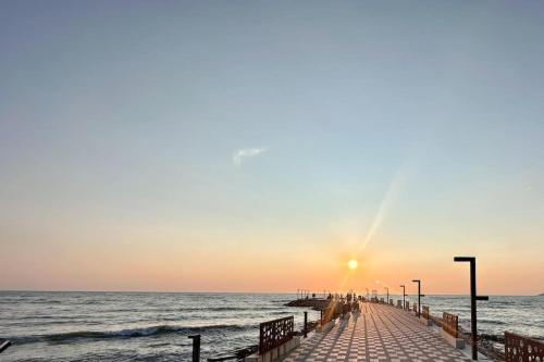 un muelle se extiende hacia el océano al atardecer en H&E Sea view 2-Bedroom Apt Qerret, en Golem
