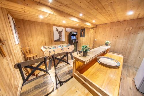 Ce chalet en bois comprend une table et un banc. dans l'établissement Les Marmottes, 10 à 20p avec bb-foot, billard, bar, à Cornimont