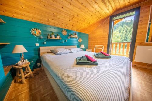 Cette chambre en bois comprend un grand lit. dans l'établissement Les Marmottes, 10 à 20p avec bb-foot, billard, bar, à Cornimont