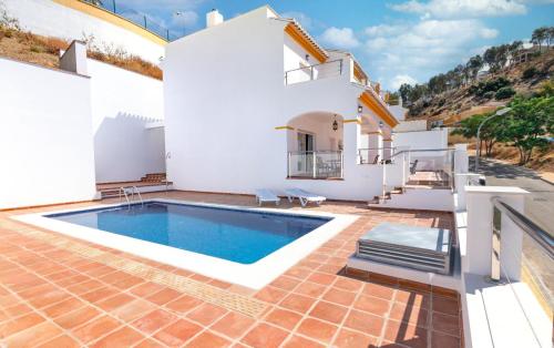a villa with a swimming pool in front of a house at Exlusivo Chalet Benagalbón in Málaga