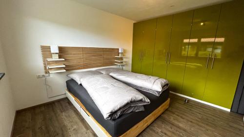 ein Schlafzimmer mit einem Bett mit einer grünen Wand in der Unterkunft Ferienwohnung Wiesenweg in Seeg