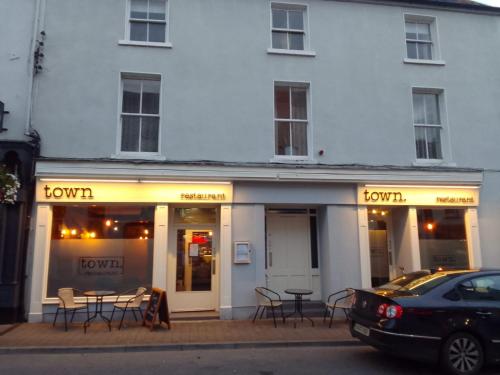 a white building with a table and chairs in front of it at Keeles Townhouse in Birr
