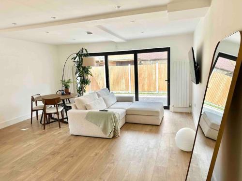 ein Wohnzimmer mit einem weißen Sofa und einem Tisch in der Unterkunft Luxurious, spacious, sunny & modern apartment in London