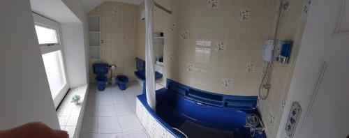 ein Badezimmer mit zwei blauen WCs und einer Dusche in der Unterkunft Keeles. in Birr