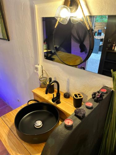 a bathroom with a black sink and a mirror at Caraiba Villa & Bungalows in Sainte-Anne