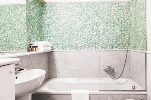 a bathroom with a shower and a tub and a sink at Brera Apartments Alla Scala in Milan