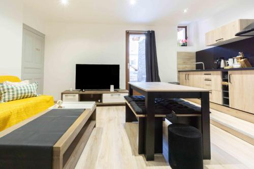 un salon avec une table et une télévision dans l'établissement Saint Antoine en montagne, à Saint-Jean-de-Maurienne