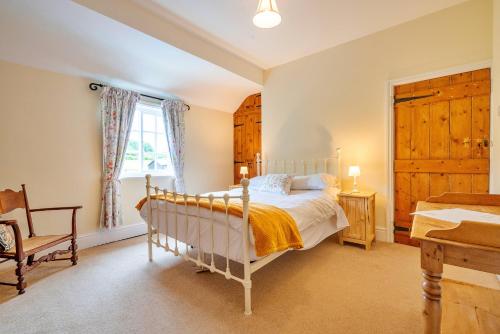 a bedroom with a bed and a chair and a window at Finest Retreats - Marmaduke Cottage in Sancton