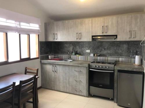a kitchen with a stove and a table in it at Charming 1-Bed Studio in Huanchaco with balcony in Huanchaco