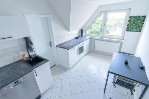 a white kitchen with a sink and a window at Essens Grüne Mitte , Direkt an der KEM Klinik, Freie Parkplätze und Netflix in Essen