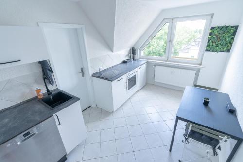 een witte keuken met een wastafel en een raam bij Essens Grüne Mitte !Zentral, Grün und Heimisch! Free Parking, Free Netflix in Essen