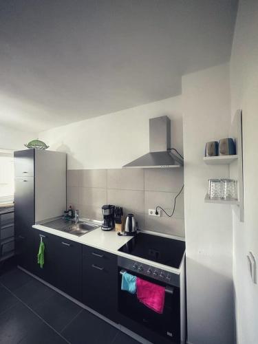 a kitchen with a sink and a stove top oven at Rückersdorf - IKON Immoleasing in Rückersdorf