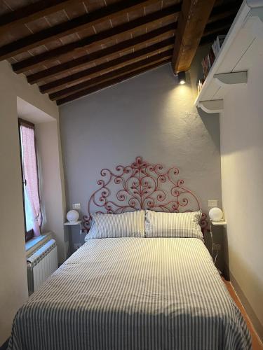 a bedroom with a large bed with a striped bedspread at Appartamento centro storico La Pulcianella con vista in Montepulciano