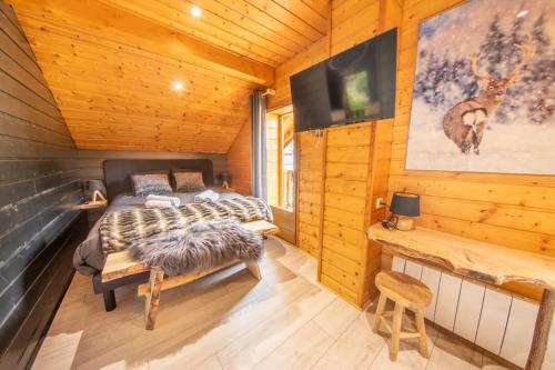 a bedroom with two beds in a log cabin at F'amis Lodge, 10 à 20p et sauna in Cornimont