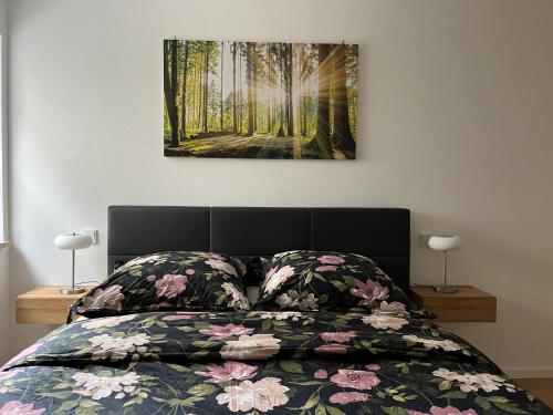 a bedroom with a bed with a painting on the wall at Ferienwohnung mit Garten und Ausblick in Windorf