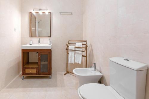 a white bathroom with a toilet and a sink at Ferrel Apartment in Ferrel