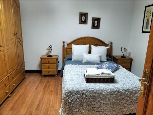 um quarto com uma cama com duas mesas de cabeceira e duas mesas em EL LLANETE em Vega de San Mateo