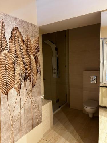 a bathroom with a wall mural of a plant at BeigeRoom in Warsaw