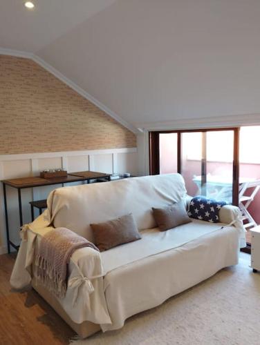 a white couch sitting in a living room at MC LAGOS, Bueu in Pontevedra