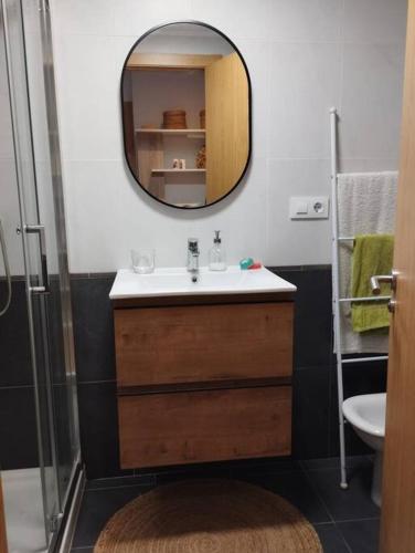a bathroom with a sink and a mirror at MC LAGOS, Bueu in Pontevedra