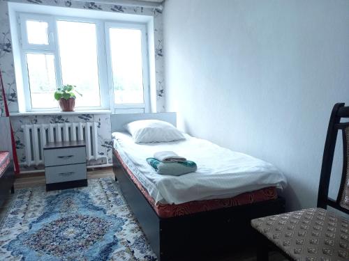 una piccola camera con letto e finestra di Dasha Guest House 2 a Naryn