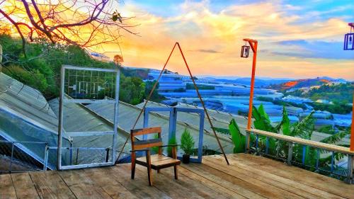 a balcony with a chair and a view of a river at Dốc Nhà Tây in Da Lat