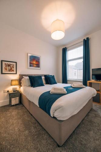 a bedroom with a large bed with blue pillows at Hanson House in Redcar
