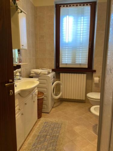 a bathroom with a sink and a toilet and a window at Casa Margherita in Mozzecane