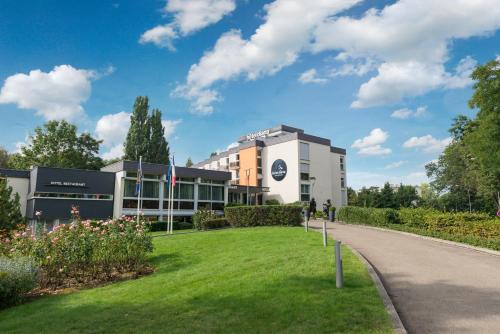 a building with a lawn in front of it at Hôtel Diana Restaurant & Spa by HappyCulture in Molsheim