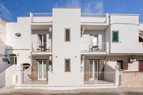 an apartment building with white walls and balconies at Le Dune Luxury Rooms in Vieste