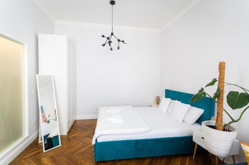 Un dormitorio con una cama azul y una planta en maceta. en Blau Apartment UltraCentral Timisoara, en Timisoara