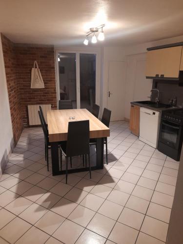 une cuisine et une salle à manger avec une table et des chaises dans l'établissement Djo, à Moutiers