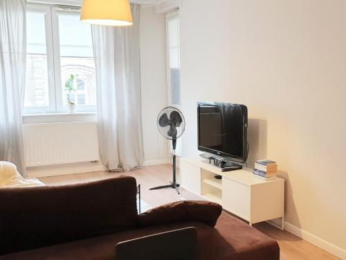 uma sala de estar com um sofá e uma televisão de ecrã plano em Klimatyczny apartament z balkonem w samym centrum Wrocławia - W6 em Breslávia
