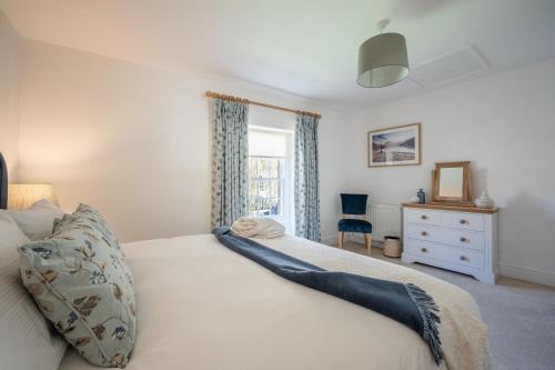 a bedroom with a bed and a window and a dresser at Bank House in Chipping Campden