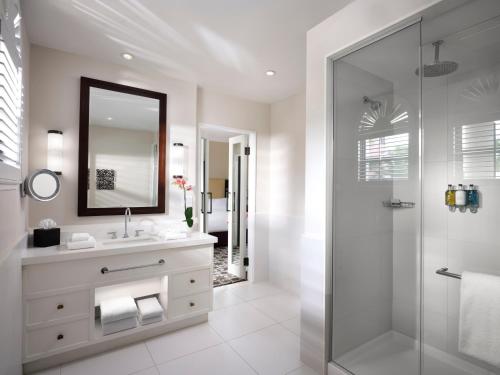 uma casa de banho com um lavatório, um espelho e um chuveiro em Cloister at The Boca Raton em Boca Raton