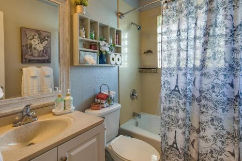 a bathroom with a toilet sink and a shower curtain at Cozy Norman Home 4 Mi to Oklahoma University! in Norman