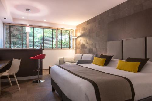 モルスアイムにあるHôtel Diana Restaurant & Spa by HappyCultureの大きなベッドと椅子が備わるホテルルームです。