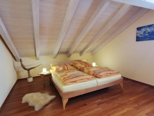 a bedroom with a bed and a wooden ceiling at Ferienwohnung Sonnenschein in Rieden am Forggensee
