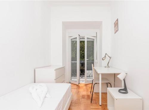 a white bedroom with a bed and a desk and a table at HOUZE_4 room apartment in Central Lisbon near Zoo in Lisbon