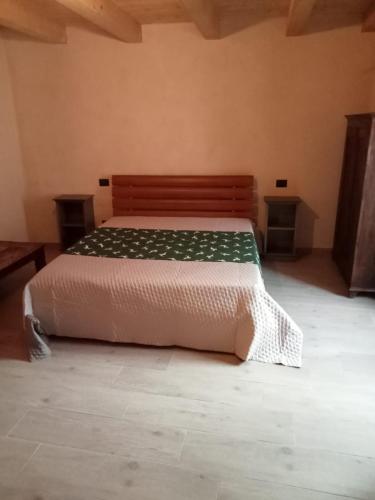 1 dormitorio con 1 cama con edredón blanco en Casa DiBiLeo, en Demonte