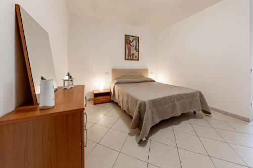 een slaapkamer met een bed en een tafel met een lamp bij H11 [Bussana 2A] Mare in Bussana Nuova