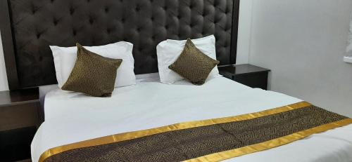 a bedroom with a large white bed with pillows at رتان للشقق المخدومة in Khamis Mushayt