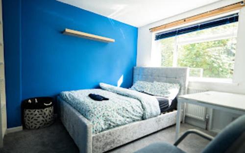 a blue room with a bed and a blue wall at Charming 6-Bed House in Reading in Reading