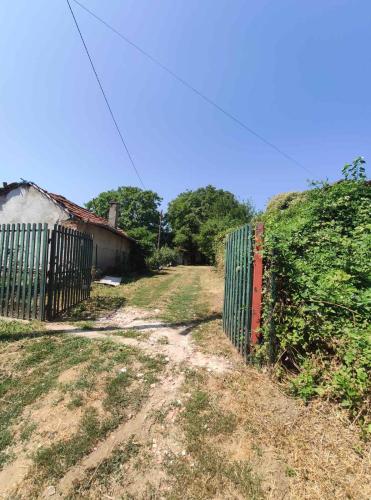 a dirt road with a fence next to a house at Park 2 Branka FREE PARKING in Vranje