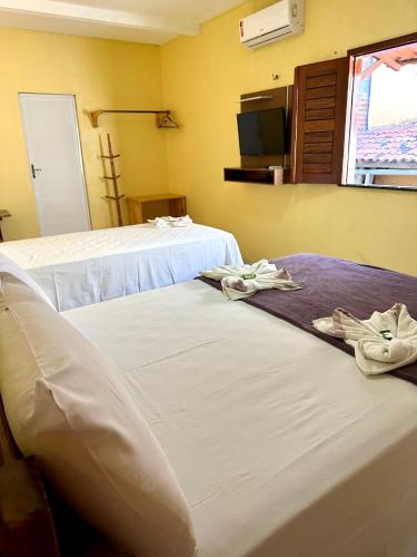 two beds in a hotel room with towels on them at Hotel Preá in Prea
