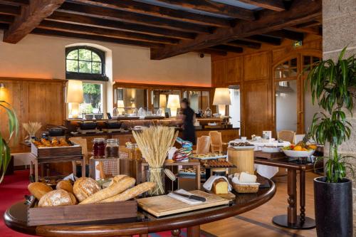 a large room with a table with bread on it at Hôtel & Spa de La Bretesche in Missillac