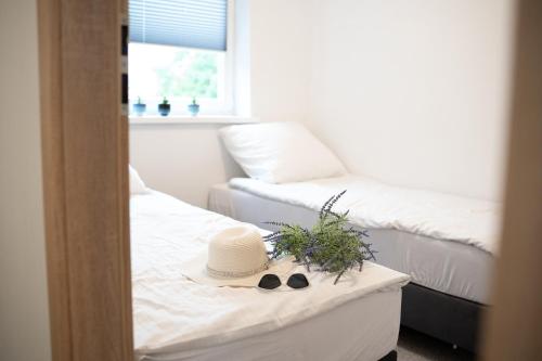 a room with a bed with a hat and pair of shoes at Domek Letniskowy Soluch in Rewal