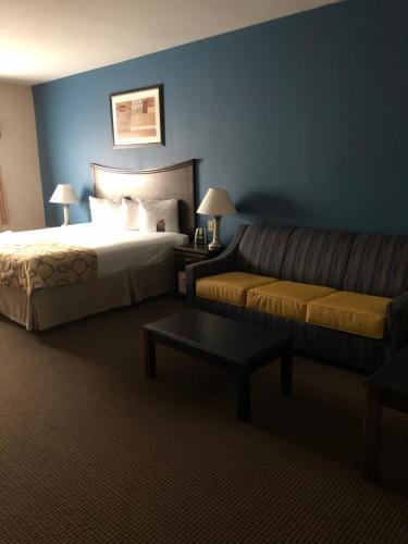 a hotel room with a bed and a couch at Baymont by Wyndham Decatur in Decatur