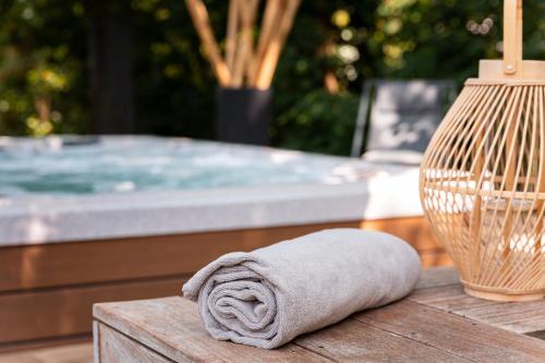 a towel sitting on a table next to a tub at Hôtel Diana Restaurant & Spa by HappyCulture in Molsheim