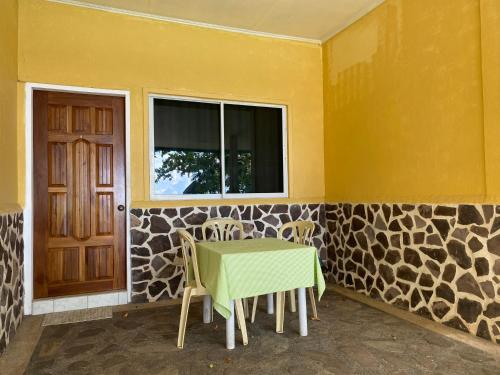 a room with a table and chairs and a window at Camiguin Island Golden Sunset Beach Club in Mambajao